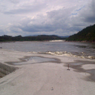 Looking upstream on the Churchill River from the top of the RCC Cofferdam, upper falls of Muskrat Falls in the distance.