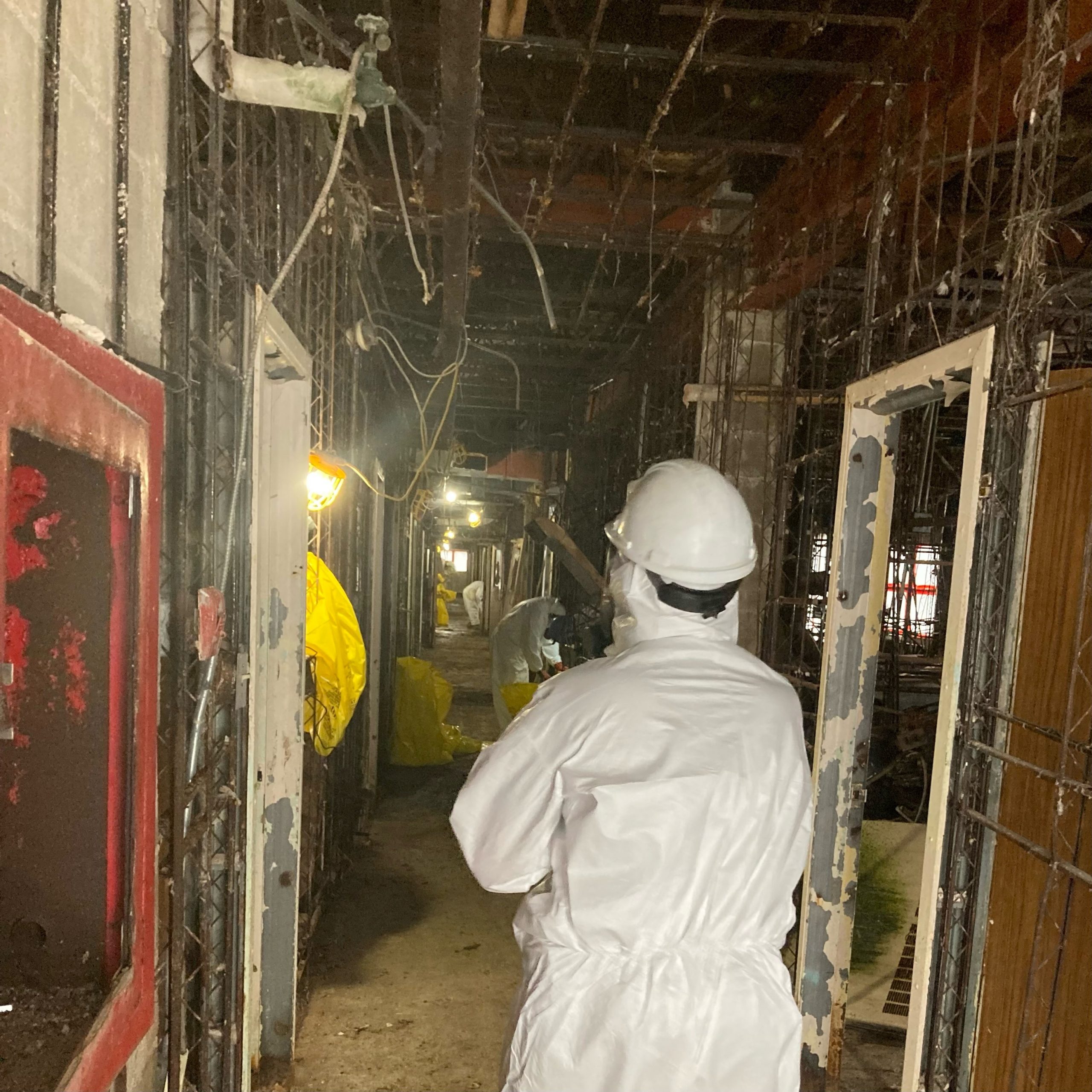 a contractor is seen in an open hallway of the old grace hospital that has been completely demolished inside.