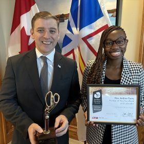 Premier Furey accepts the Golden Scissors Award from Beatrix Abdul Azeez, CFIB Policy Analyst, in his office in St. John’s, N.L.